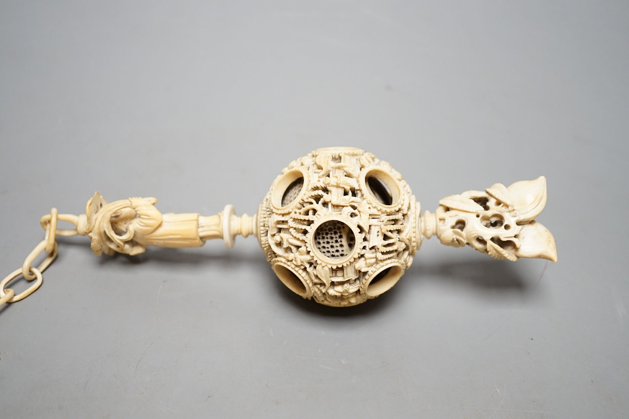 A 19th century Chinese export ivory puzzle ball., 31 cms long including chain.
